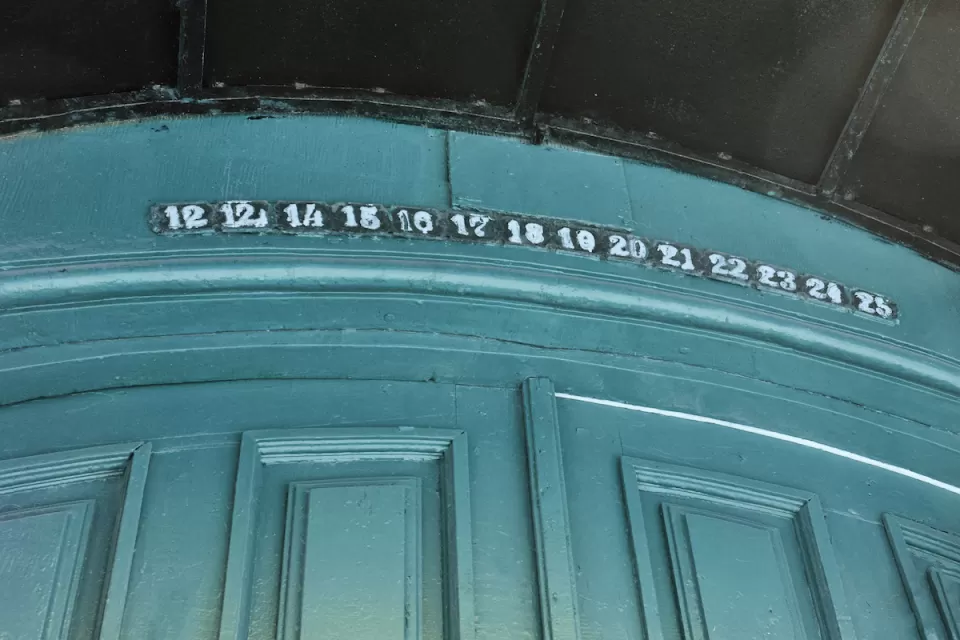 Green wall with floor or apartment numbers missing number 13, goes from 12 to 12 1/3 to 14 instead.